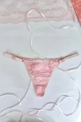 Tanga de tiro medio confeccionada en puntilla elastizada color rosado, con cola en algodón elastizado. Los costados son regulables y el fundillo es de algodón 100%.
