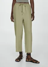 Pantalón color crudo de lino, corte recto, tiro medio, con cintura elástica ajustable con lazo, bolsillos laterales y traseros.