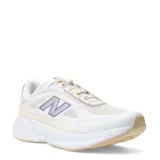 Championes New Balance modelo Training Cat, color beige y blanco con detalles en lila y plateado. Presentan una suela gruesa y un diseño de malla transpirable.