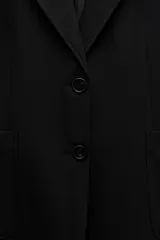 Blazer recta negra de Zara Woman Collection, con cuello solapa, manga larga con abertura y botones, bolsillos de plastrón en delantero, forro interior a tono y cierre frontal con botones.