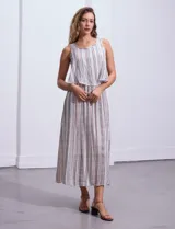 Vestido largo sin mangas, con estampado a rayas verticales en tonos beige, marrón y blanco. Tiene escote redondo y corte a la cintura con punto smock.