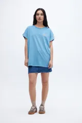 Musculosa celeste con estampado pequeño en el pecho, corte oversize y mangas con dobladillo.