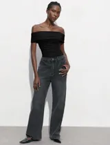 Body negro con escote bote drapeado y broches inferiores.