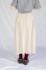 Falda midi color beige de microfibra con cintura elastizada y frunces laterales.