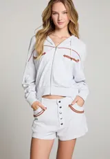 Campera gris con capucha, cierre frontal y detalles de flechas marrones en el pecho y los hombros.