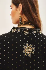 Kimono negro con bordados dorados de flores y lentejuelas. Corte holgado y mangas 3/4.