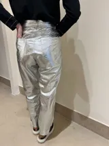 Pantalón de cuero plateado, cómodo y suave, con tajo corto en el bajo y pespunte a contratono en camel.