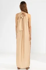 Vestido largo color beige con estampado floral marrón, corte recto, cuello halter y espalda descubierta.