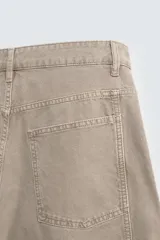 Pantalón de jean color beige, corte holgado y amplio en toda la pierna, tiro medio, tejido rígido, cinco bolsillos, efecto lavado y detalle de pinzas en perneras.