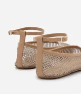Zapatilla tipo bailarina color beige, con capellada de red calada, puntera redonda y tira de charol con hebilla en el tobillo.