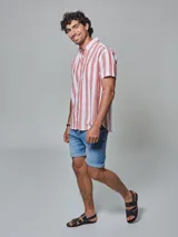 Bermuda de jean de lavado medio con ruedo de color, dos bolsillos laterales, dos en la parte posterior y uno cerillero. Cierre frontal y botón.