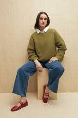 Sweater de punto color salmón con cuello redondo y mangas anchas. Presenta un diseño calado en la parte superior y tejido tramado horizontal en el resto del cuerpo.