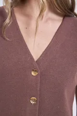 Chaleco de punto sin mangas, color rosado, con escote en V y cierre frontal de tres botones marrones.