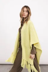 Ruana tejida en lana merino color amarillo pastel, con terminación de flecos.