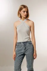 Top cropped gris metalizado con cuello halter y detalle de studs.