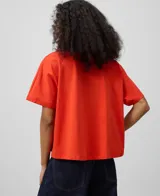 Remera color naranja de corte evasé, cuello redondo y mangas cortas con dobladillo.