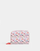 Billetera pequeña de cuerina color blanco con estampado de lazos rosas y corazones. Tiene cierre circundante y tirador de goma.