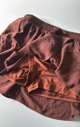 Minifalda marrón con volados y cintura elastizada. Incluye short interno.