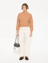 Sweater color camel de tejido cerrado, con cuello redondo y mangas largas.