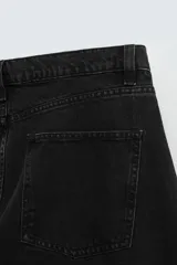Pantalón de jean negro de corte amplio, estilo balloon fit, con cinco bolsillos y cierre frontal con botones.