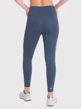 Calza deportiva color beige, tiro alto, con bolsillos laterales y banda de silicona en la cintura.