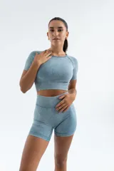 Conjunto deportivo celeste con efecto lavado, compuesto por remera crop top de manga corta y short ajustado.