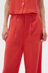 Pantalón de viscosa color beige, de corte ancho y tiro alto, con bolsillos laterales.