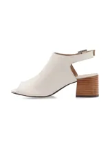 Sandalia peep toe color blanco hueso, confeccionada en cuero, con taco de madera y hebilla metálica.