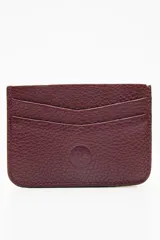 Tarjetero de cuero color marrón con tres ranuras para tarjetas y logo grabado en el frente.