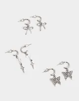 Set de tres pares de aros argolla plateados con dijes colgantes: moño, mariposa y estrella con cristal.
