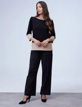 Buzo de tejido combinado en negro y beige, con aplicación de cierre metálico en los hombros y manga tres cuartos.