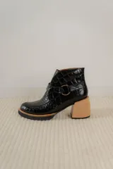 Botas cortas de cuero negro con textura tipo cocodrilo, caña alta, cierre con hebilla y taco de madera.