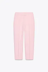 Pantalón tobillero de vestir color rosa pálido, de corte slim y tiro alto. Cuenta con bolsillos delanteros y falsos bolsillos de vivo en la espalda. El cierre es frontal con cremallera, botón interior y gancho.