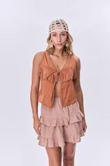Chaleco color ladrillo con flecos en el pecho y lazo de ajuste en el centro.