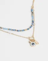 Collar corto multicadena dorado con cadena de corazones, cuentas azules y dijes místicos.
