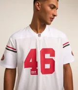 Remera deportiva blanca de manga corta con tecnología Dry, cuello en V, detalles de rayas en mangas y cuello, y estampado del logo de los San Francisco 49ers.