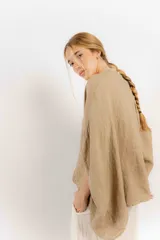 Camisa celeste de lino con corte amplio, cuello mao y mangas cortas. Presenta cierre frontal con botones y ribete negro en cuello y tapeta.