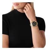 Reloj Michael Kors modelo Bradshaw, color dorado con esfera negra y números romanos. Cuenta con cronógrafo y calendario.