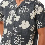 Camisa de manga corta con estampado de flores y espirales en tonos blanco y beige sobre fondo negro.