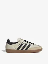 Zapatillas Adidas Samba OG de cuero color crema con detalles en negro y suela de goma marrón.