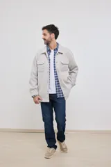 Sobrecamisa color gris claro con cuello clásico, cierre frontal con botones, dos bolsillos con solapa en el pecho y corte holgado.