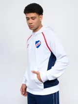 Canguro hoodie azul con capucha, cordones ajustables, bolsillo canguro y detalles en blanco y rojo en los costados y mangas. Incluye el logo de Umbro y el escudo del Club Nacional de Football en el pecho.