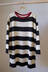 Sweater tejido artesanal a rayas horizontales color marrón y beige, con cuello redondo rojo y mangas 3/4 acampanadas.