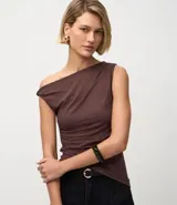 Blusa sin mangas color amarillo claro, confeccionada en microfibra, con escote asimétrico de un solo hombro, detalle torcido en el hombro y fruncidos en el cuerpo. Presenta un bajo asimétrico.