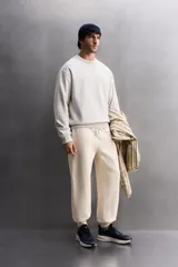 Sudadera de entrenamiento color gris claro, de corte relaxed fit, confeccionada en tejido de algodón con interior de rizo. Tiene cuello redondo, manga larga y acabados en rib.