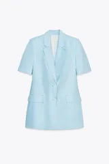 Blazer celeste de lino con cuello solapa, manga corta con hombreras, bolsillos delanteros con solapa, cintura entallada y cierre frontal con botones.