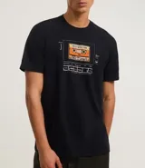 Remera negra de algodón con estampa frontal de una cinta cassette con la leyenda "Best Hits 1984".
