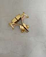 Sandalia plateada de cuero vacuno con taco cuadrado de 6 cm y tira delantera con nudo.