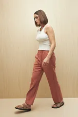 Pantalón beige de tiro medio con cintura elastizada y cordón regulable, bolsillos laterales y calce relajado.