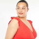 Traje de baño entero rojo con escote en V cruzado y volantes en los hombros.